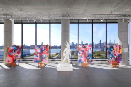 Exhibition space with colorful artworks and installations with a view of Manhattan skyline