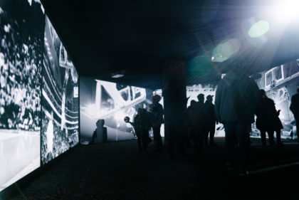 Multi channel video projection showing a basketball game in a dark exhibition space